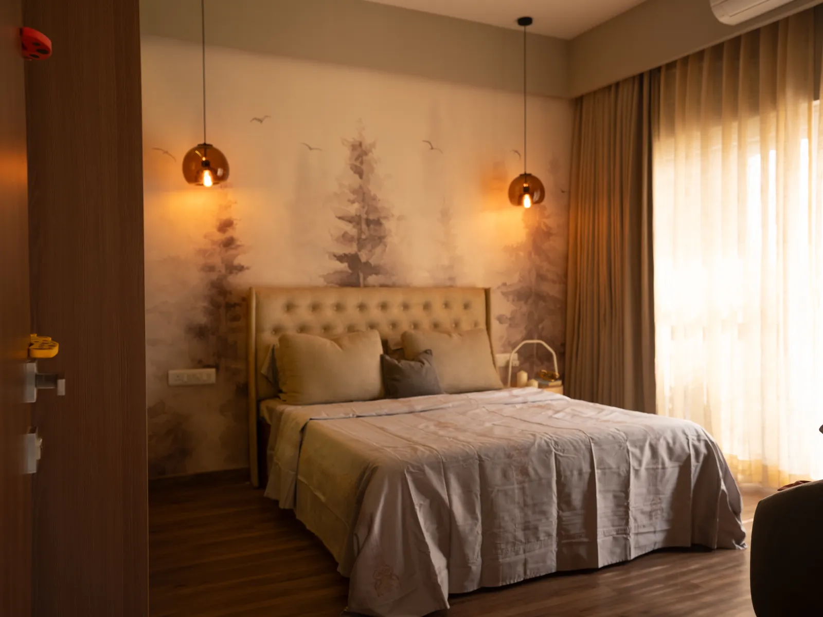 Tufted bed against a forest mural wall — Amlan's Residence